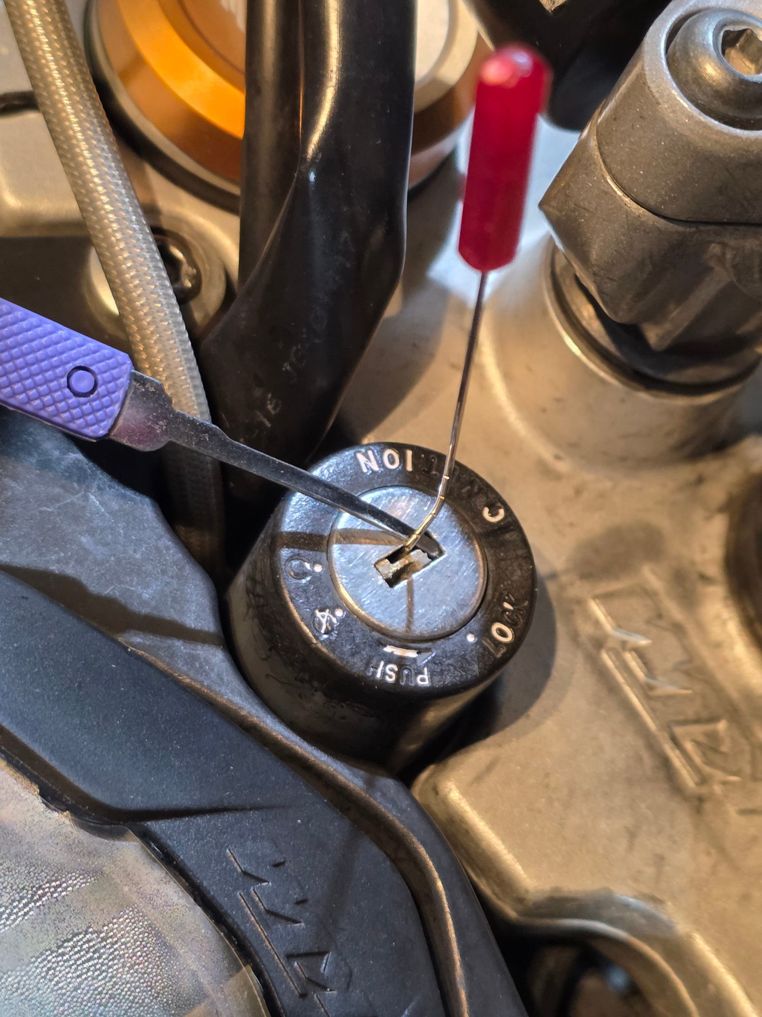 Broken motorcycle key being extracted from the ignition